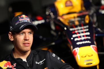 A photo of Sebastian Vettel standing in front of a yellow race car