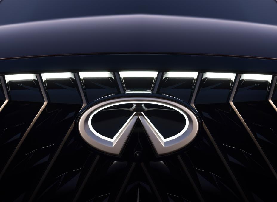 Close up of the illuminated INFINITI emblem on the grill of the QX65 Monograph.