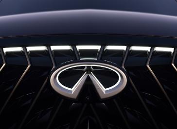 Close up of the illuminated INFINITI emblem on the grill of the QX65 Monograph.