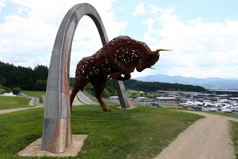 Full image of Image of a brown bull statue with gold horns standing on its hind legs under a silver arch