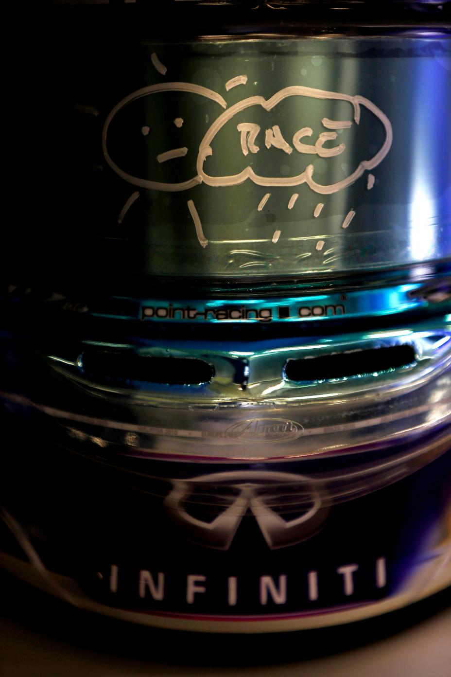 A piece of metal with the Infiniti logo and a outline of the race track.