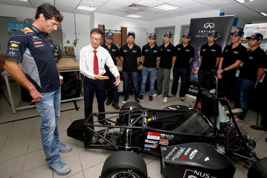 Infiniti driver talking with a team of people.