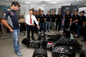 Infiniti driver talking with a team of people.