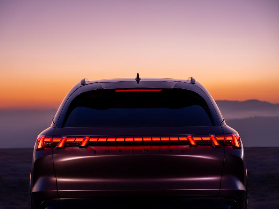 "Vue arrière du QX65 Monograph au coucher du soleil, les feux arrière sont allumés."