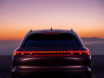 "Vue arrière du QX65 Monograph au coucher du soleil, les feux arrière sont allumés."