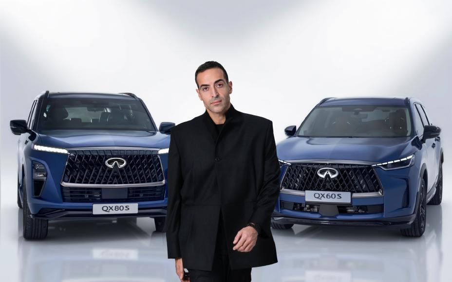Close-up of Person standing between the QX80S and QX60S
