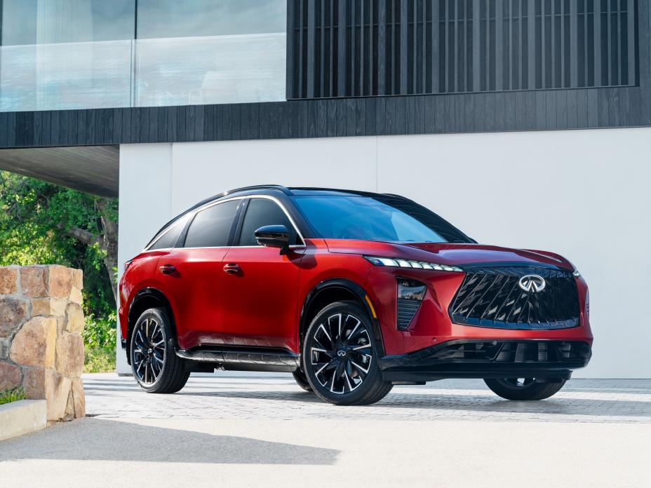 Front right 3/4 view of the 2027 INFINITI QX65 parked in front of a modern building.