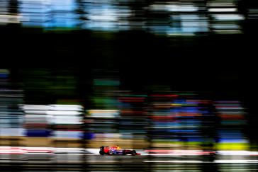 Side view of the Infiniti car driving on the race track.