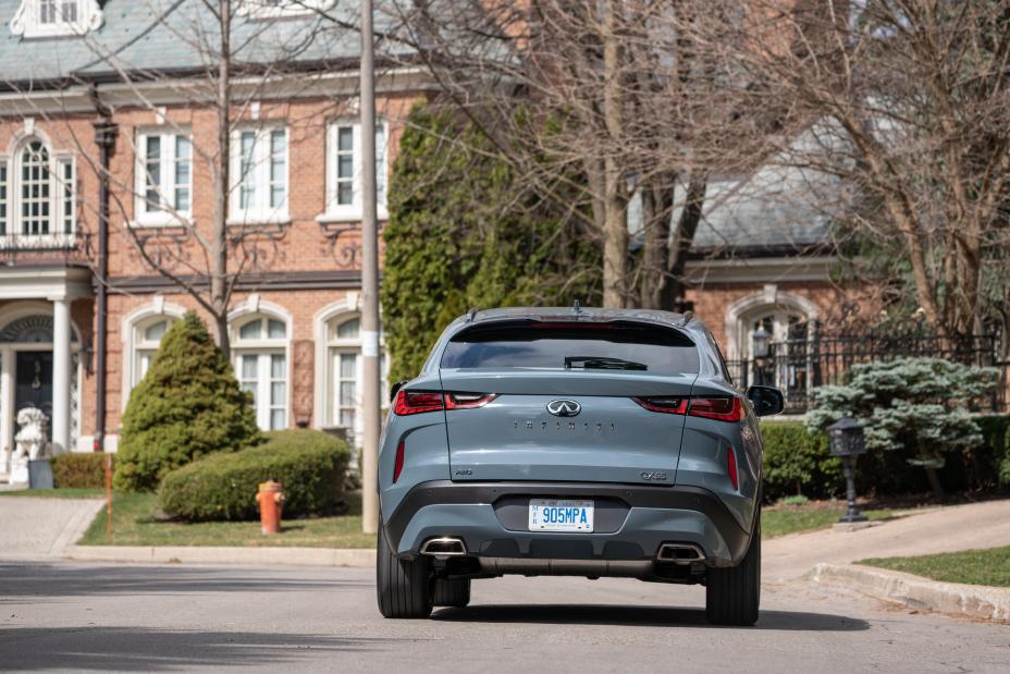 The back side of a grey QX55 on a street.
