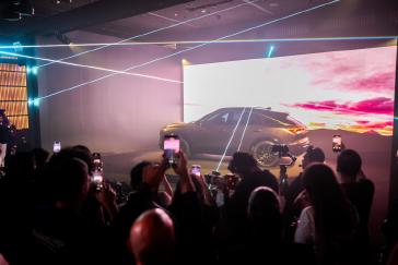 Full-side profile view of the INFINITI QX65 Monograph with audience