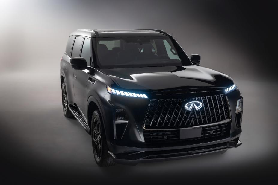 Side-angled front view of the 2026 INFINITI QX80 SUV in black, featuring LED headlights, a bold Infiniti grille, and tinted windows; set against a softly blurred neutral background that draws attention to the vehicle’s sleek design.