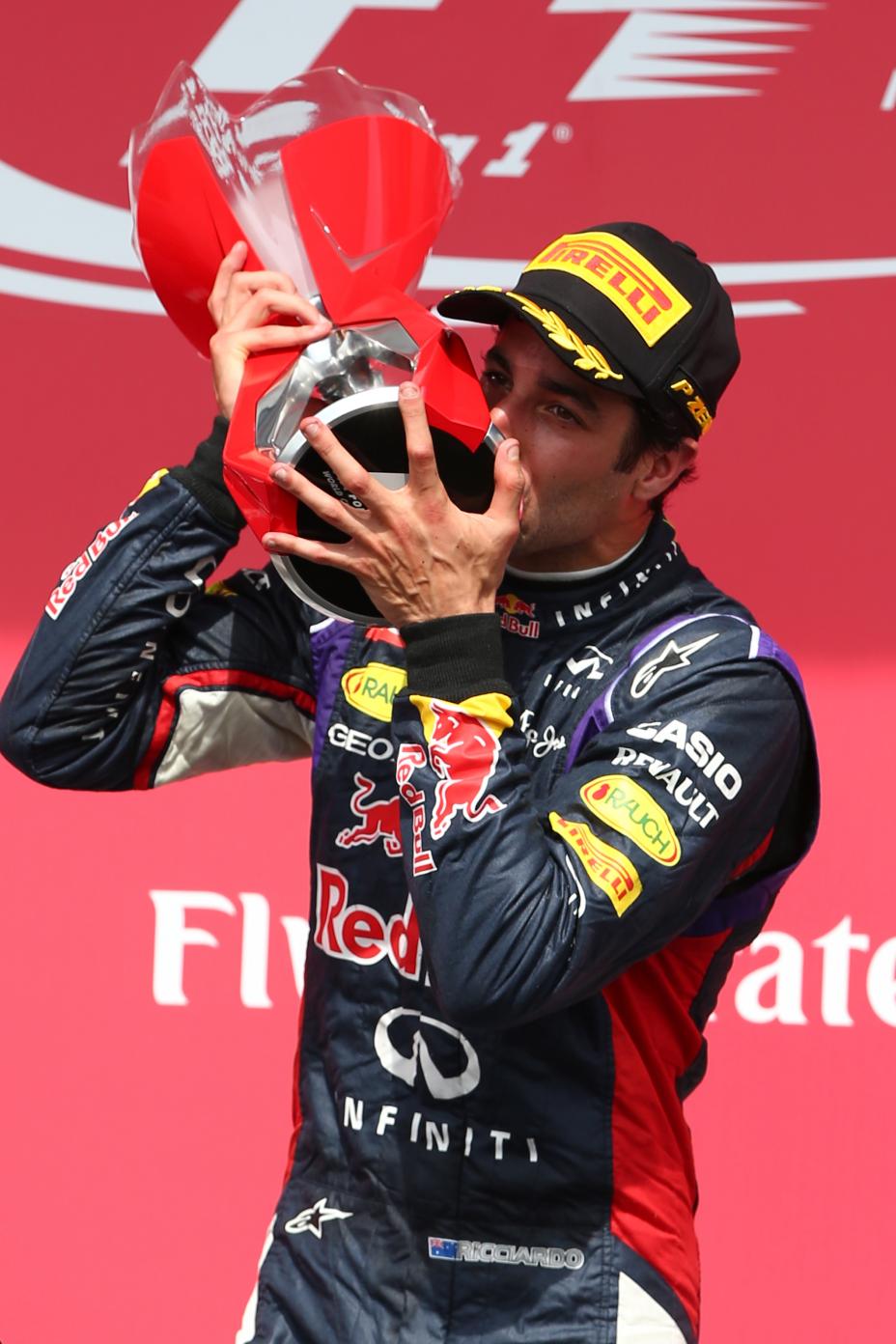 Red Bull team driver kissing the first place trophy.