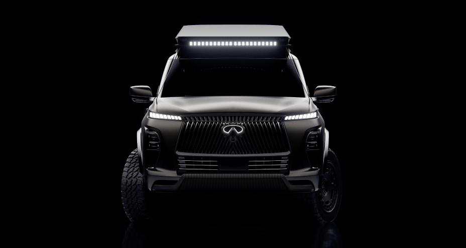 Front view of the INFINITI QX80 Terrain Spec in the dark, the headlights, emblem and light bar are illuminated.