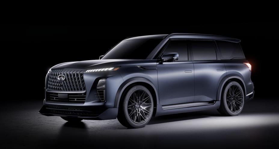 Front right 3/4 angle of the INFINITI QX80 Track Spec, light reflects off the vehicle pictured in a dark room.