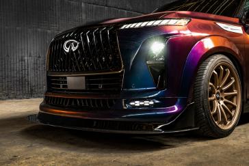 Angled close up of the INFINTI QX80 R-Spec build front fascia, the paint reflects in the light.