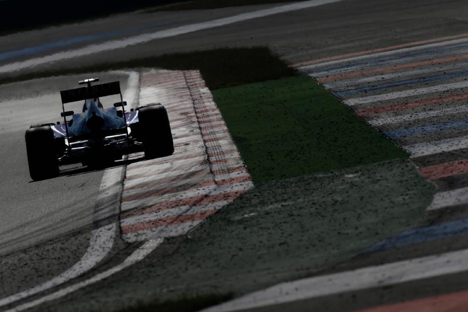 Rear view of a F1 race car driving on the track.