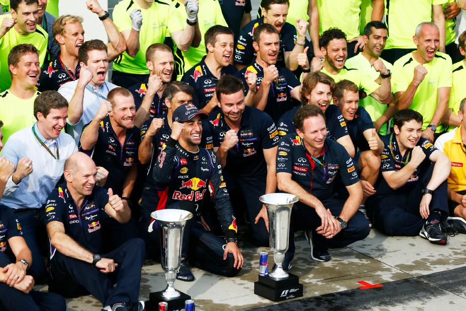 Group surrounded by Ricciardo to take a victory photo