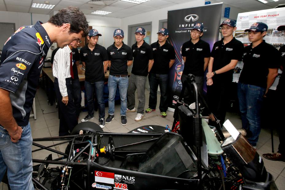 Red Bull racing team looking at the race car.