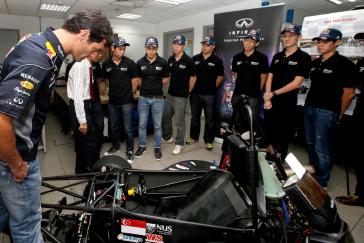 Red Bull racing team looking at the race car.