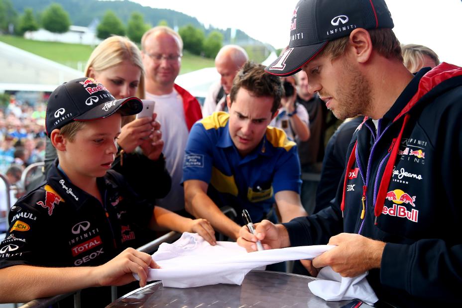 INFINITI driver signing a t-shirt for a kid