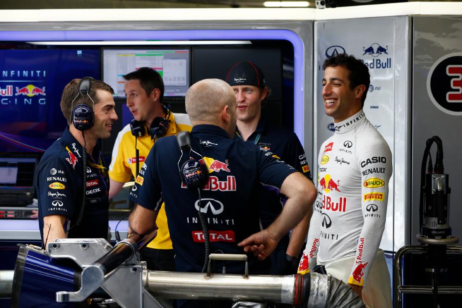 Inifiniti driver smiling big while conversing with team members