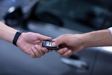 Manos entregando las llaves de un vehículo INFINITI, representando el inicio de una experiencia personalizada y el vínculo entre la marca y el cliente.