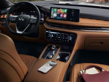 Interior de un vehículo INFINITI con vestiduras de piel capitonadas, acabados premium y sistemas tecnológicos avanzados que destacan el lujo y la innovación del segmento.
