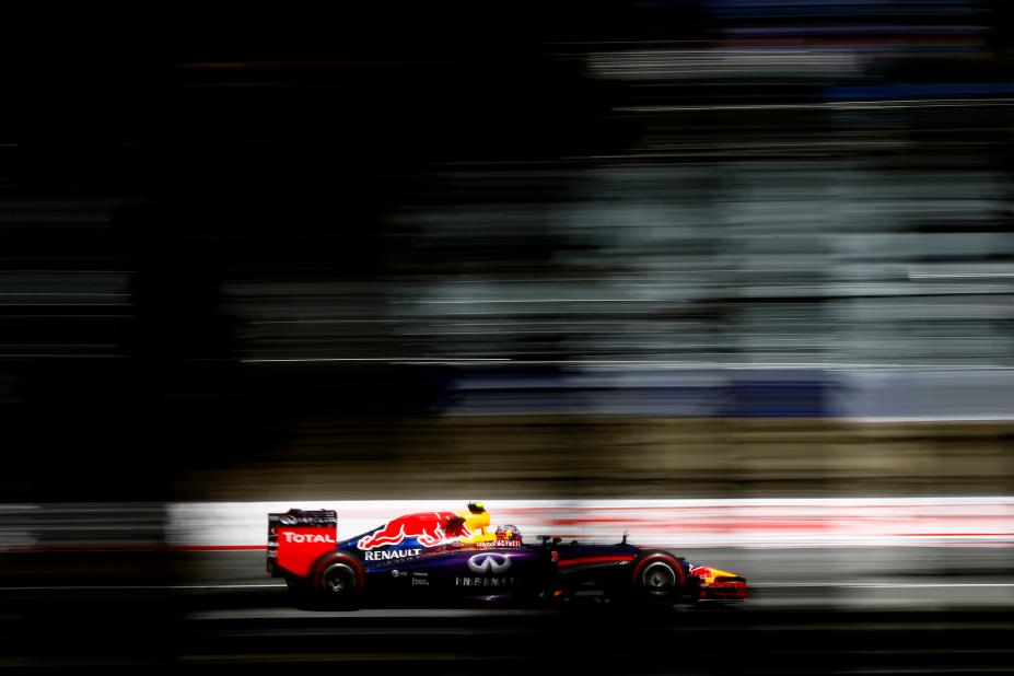 Shadowed image of INFINITI racer speeding past left to right along track