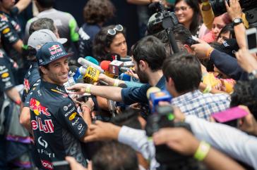 Interviewers asking questions to Formula One driver.