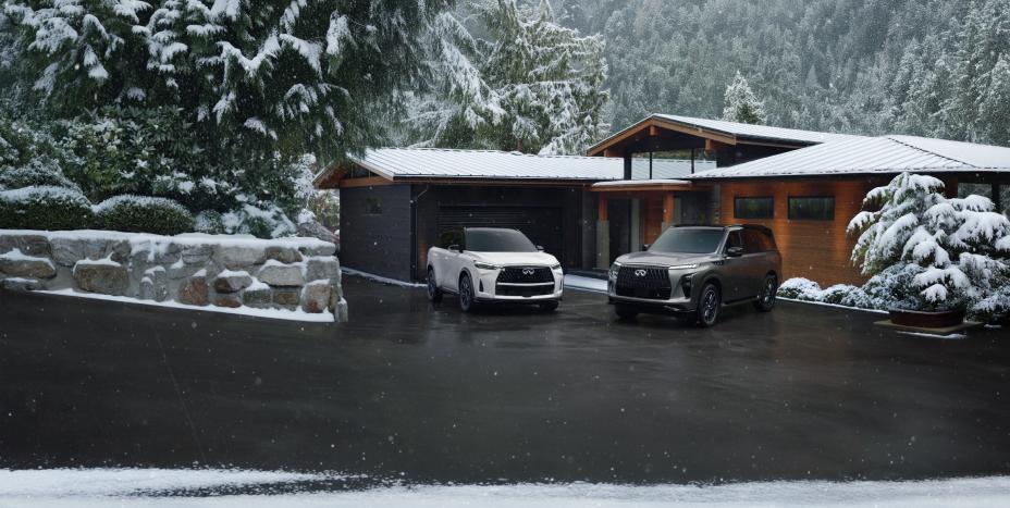 Un INFINITI QX80 et un QX60 de 2026 stationnés dans une allée devant une maison moderne sous la neige.
