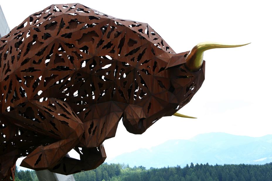 Right side image of Image of a brown bull statue with gold horns