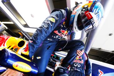 Red Bull race car driver getting into his car.