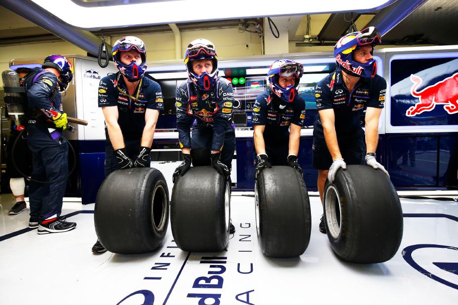Four crew members rolling four tires