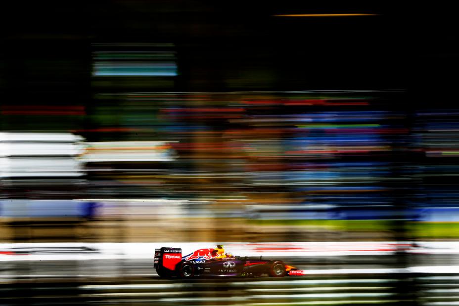 Distant image of INFINITI racer speeding along the track with a rainbow blur affect