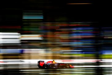 Distant image of INFINITI racer speeding along the track with a rainbow blur affect