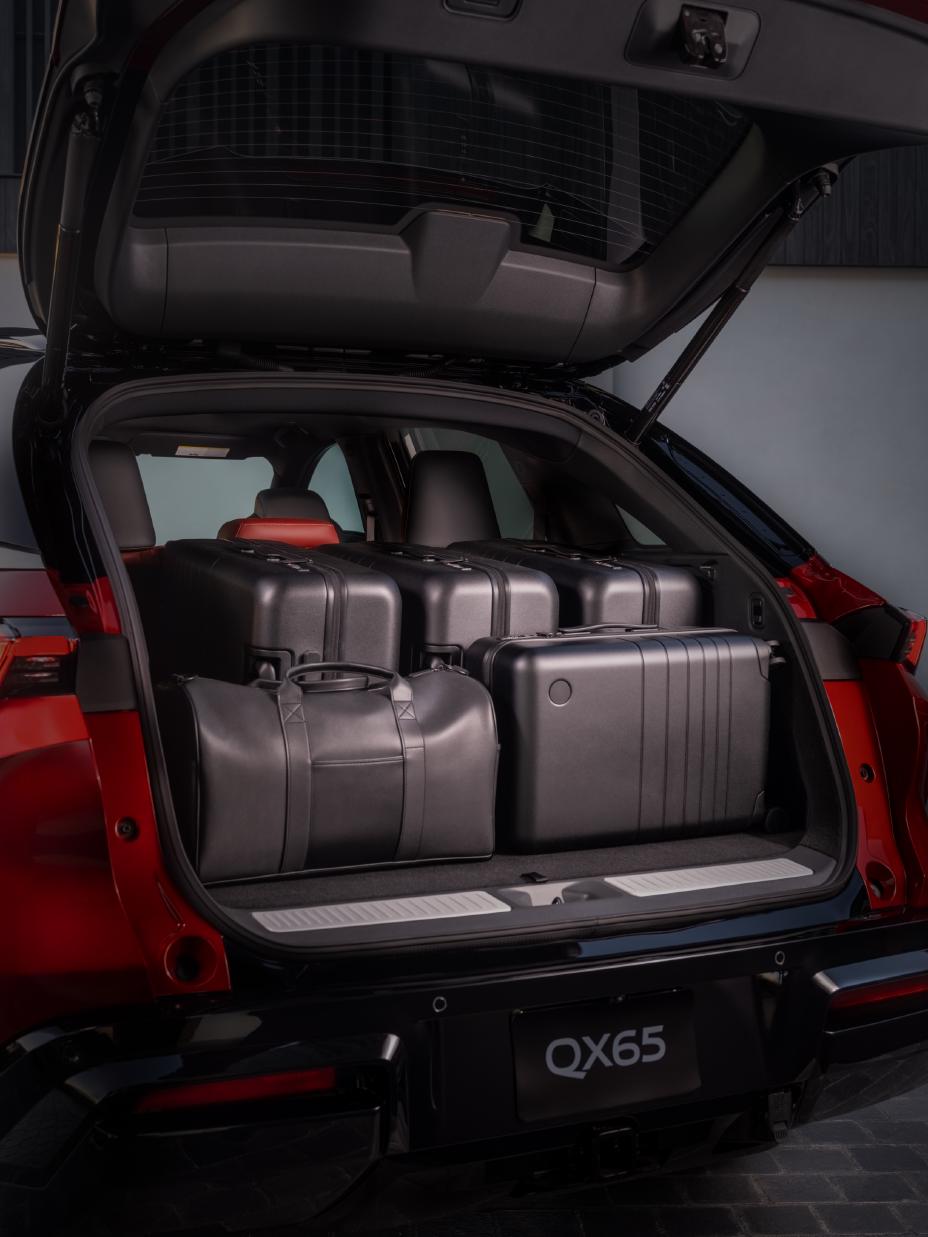 Rear view of the 2027 INFINITI QX65, displaying the cargo space with an open trunk and luggage inside.