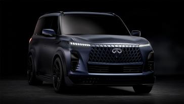 Front right 3/4 view of the INFINITI QX80 Track Spec mostly in the dark, the headlights are illuminated.