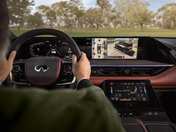 Detalle del sistema Direct Adaptive Steering en el interior de un vehículo INFINITI, mostrando los controles y elementos del volante asociados a la dirección totalmente electrónica, ubicados al alcance del conductor.