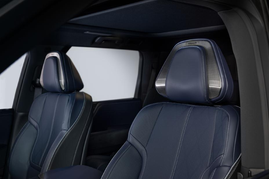 Interior view of the 2026 INFINITI QX80, focusing on the front seats upholstered in blue leather with white stitching. The seats have a modern design with integrated headrests and metallic accents.