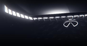 Close up of the grill on an INFINITI Concept, the headlights and emblem are illuminated.