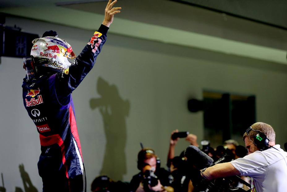 Photo of F1 driver with reporters taking photos of him.