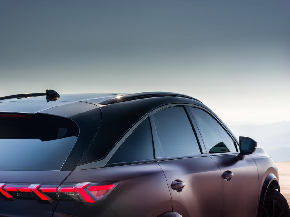 Upp close up angled view of the QX65 Monograph, the sky reflects off the body.