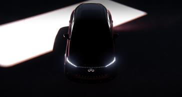 The QX65 Monograph almost fully hidden besides a faint outline and the headlights illuminated in the dark.