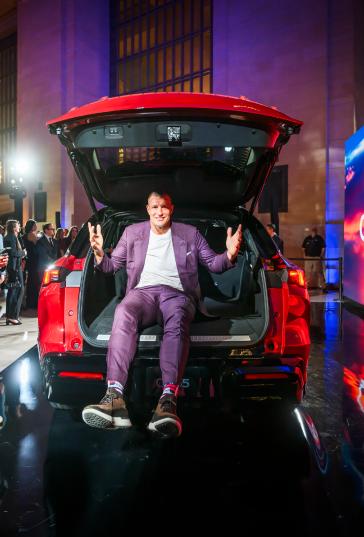 A man sitting in the trunk of the 2027 INFINITI QX65.