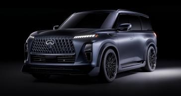 Front left 3/4 view of the INFINITI QX80 Track Spec, a spotlight illuminates the vehicle from the side.