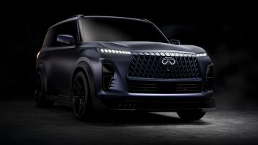 Front right 3/4 view of the INFINITI QX80 Track Spec mostly in the dark, the headlights are illuminated.