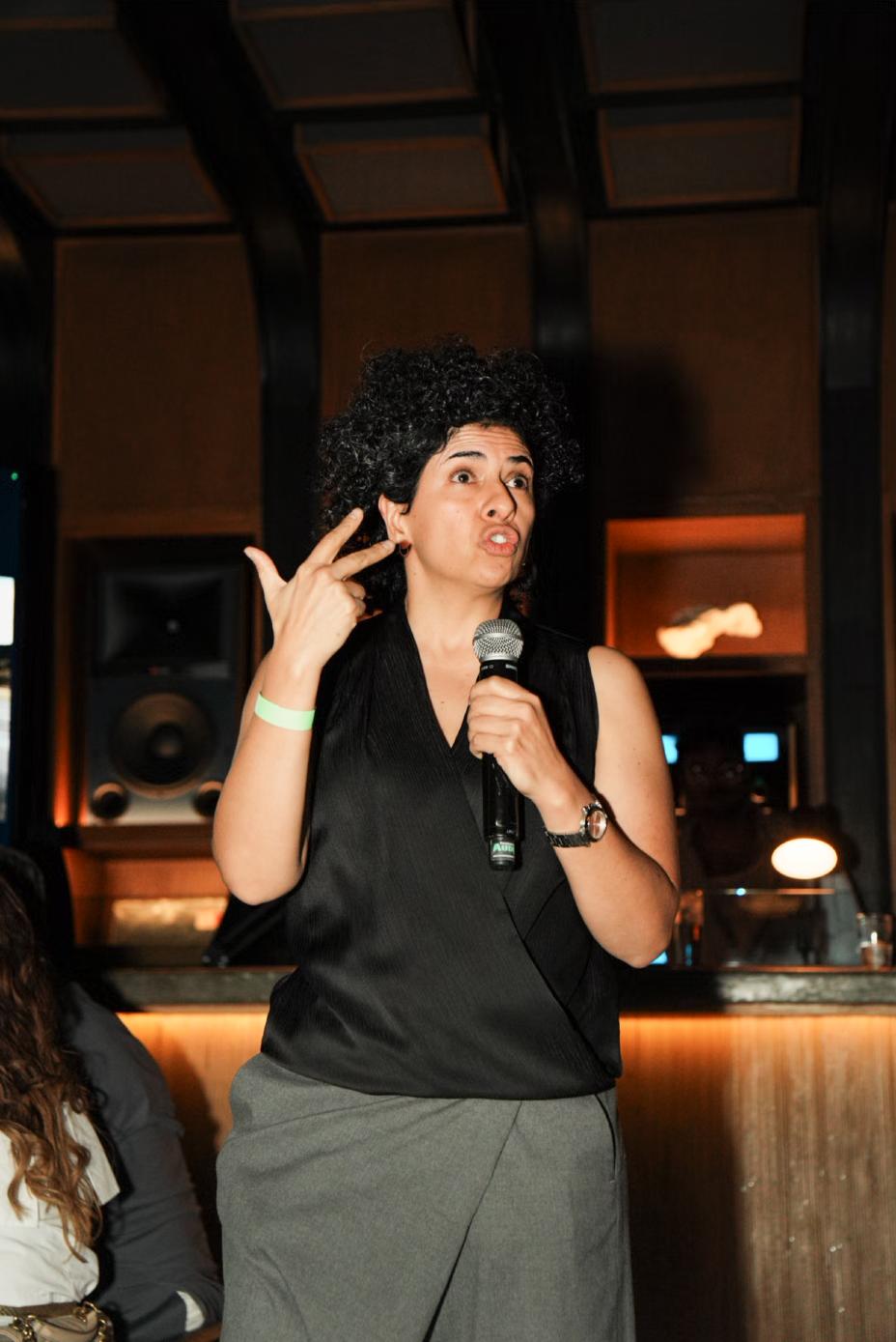 Imagen de una presentación realizada en un lugar ambientado con luz tenue, mostrando a una persona hablando frente a asistentes como parte del lanzamiento de INFINITI Membership Experience.