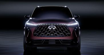 Front view of the QX65 Monograph in a dark space, the headlights are illuminated.