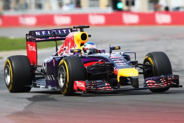 Front angled view of a multicolored F1 race car.