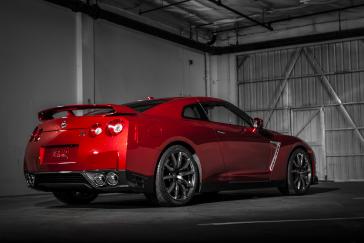 Rear angled view of the 2015 Nissan GT-R in Regal Red parked in a garage.